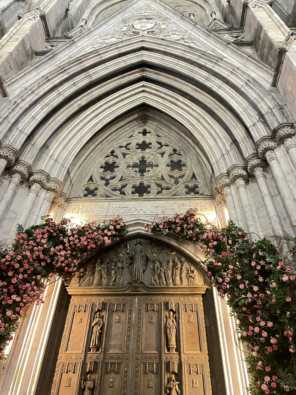 a large wooden door with a bunch of flowers on it
