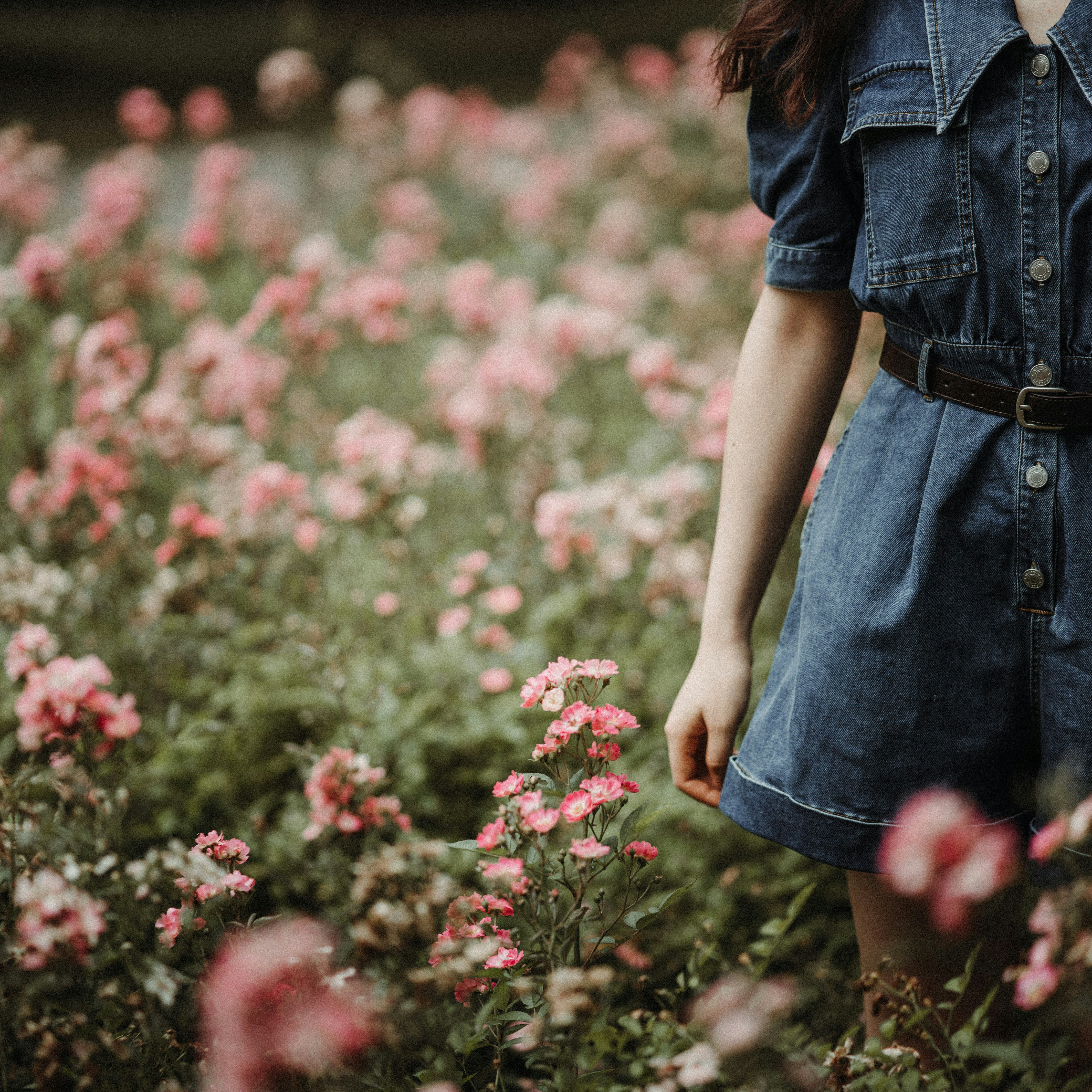 a woman standing in a field of flowers