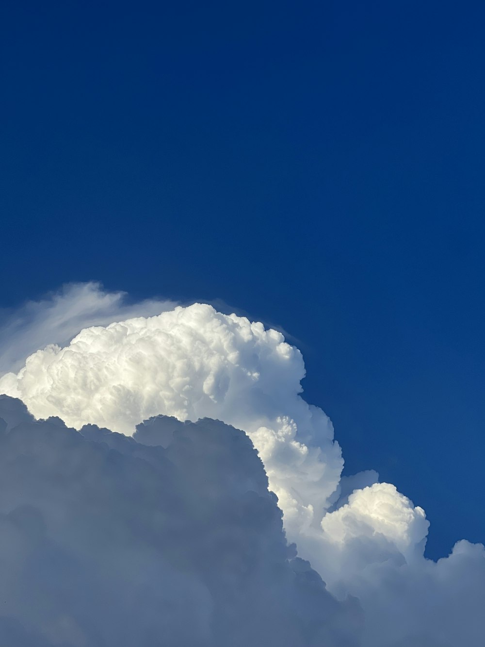 a plane flying through a cloud filled sky