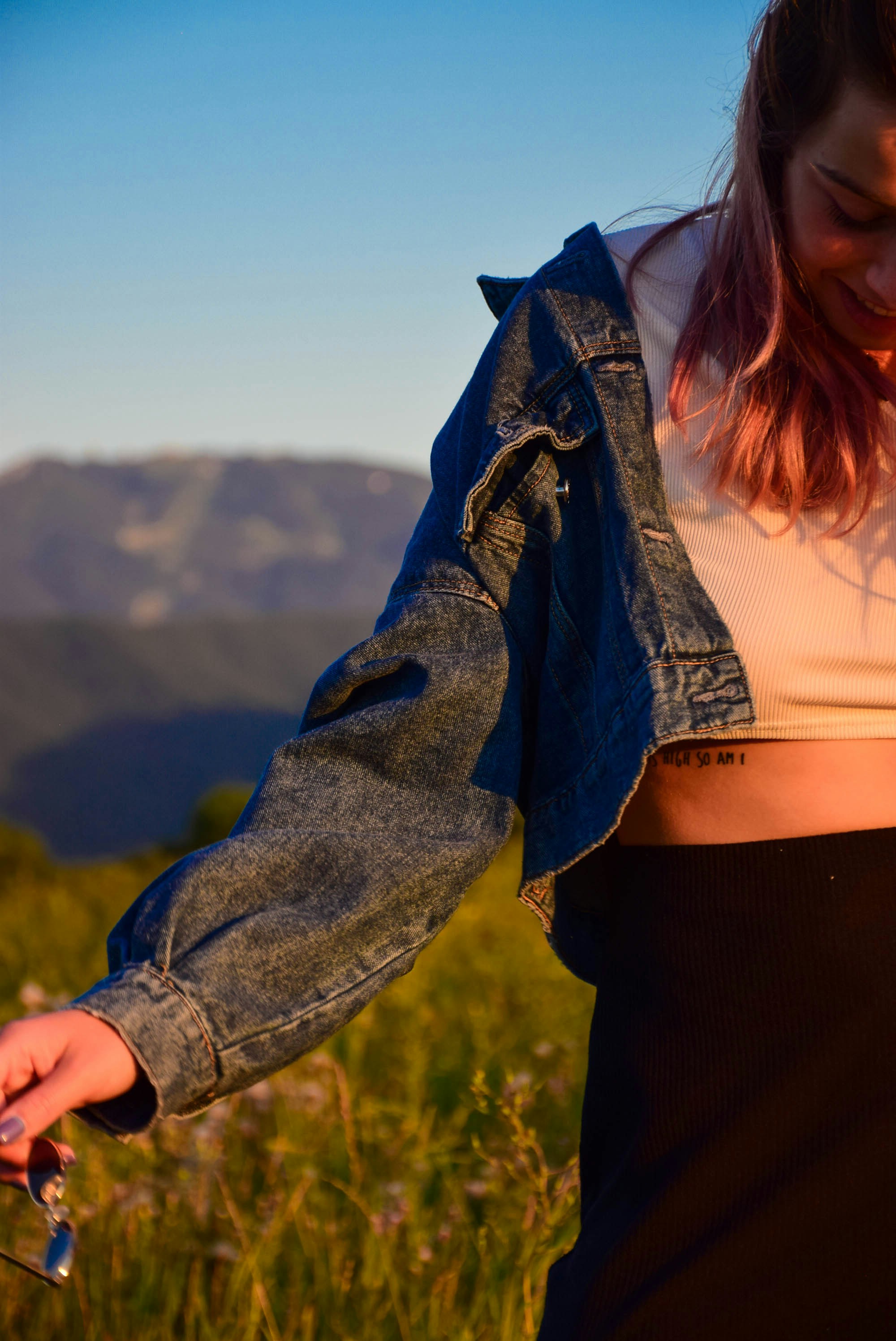 eine frau, die auf einem feld steht und ein handy hält