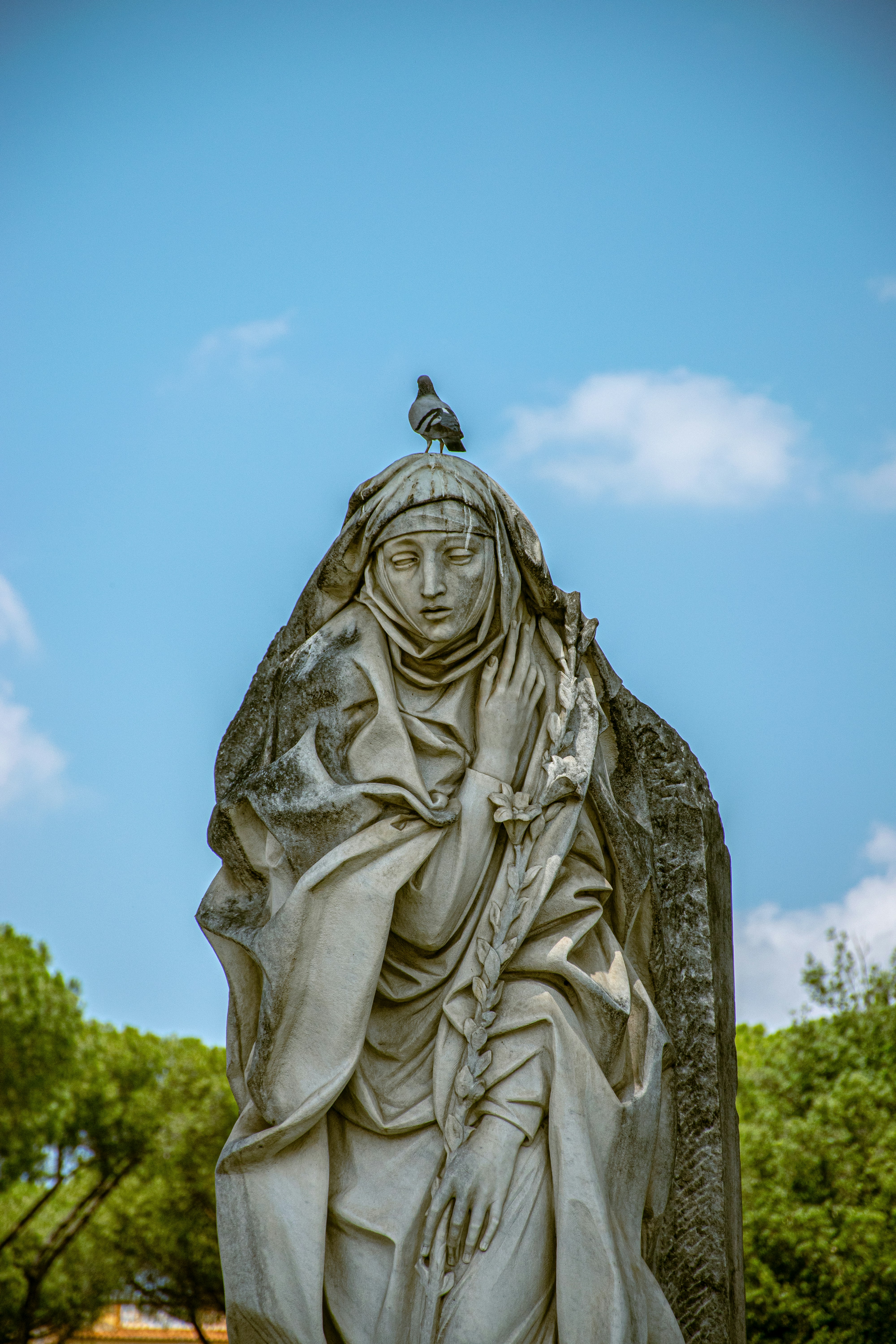 eine Statue einer Frau mit einem Vogel auf der Schulter