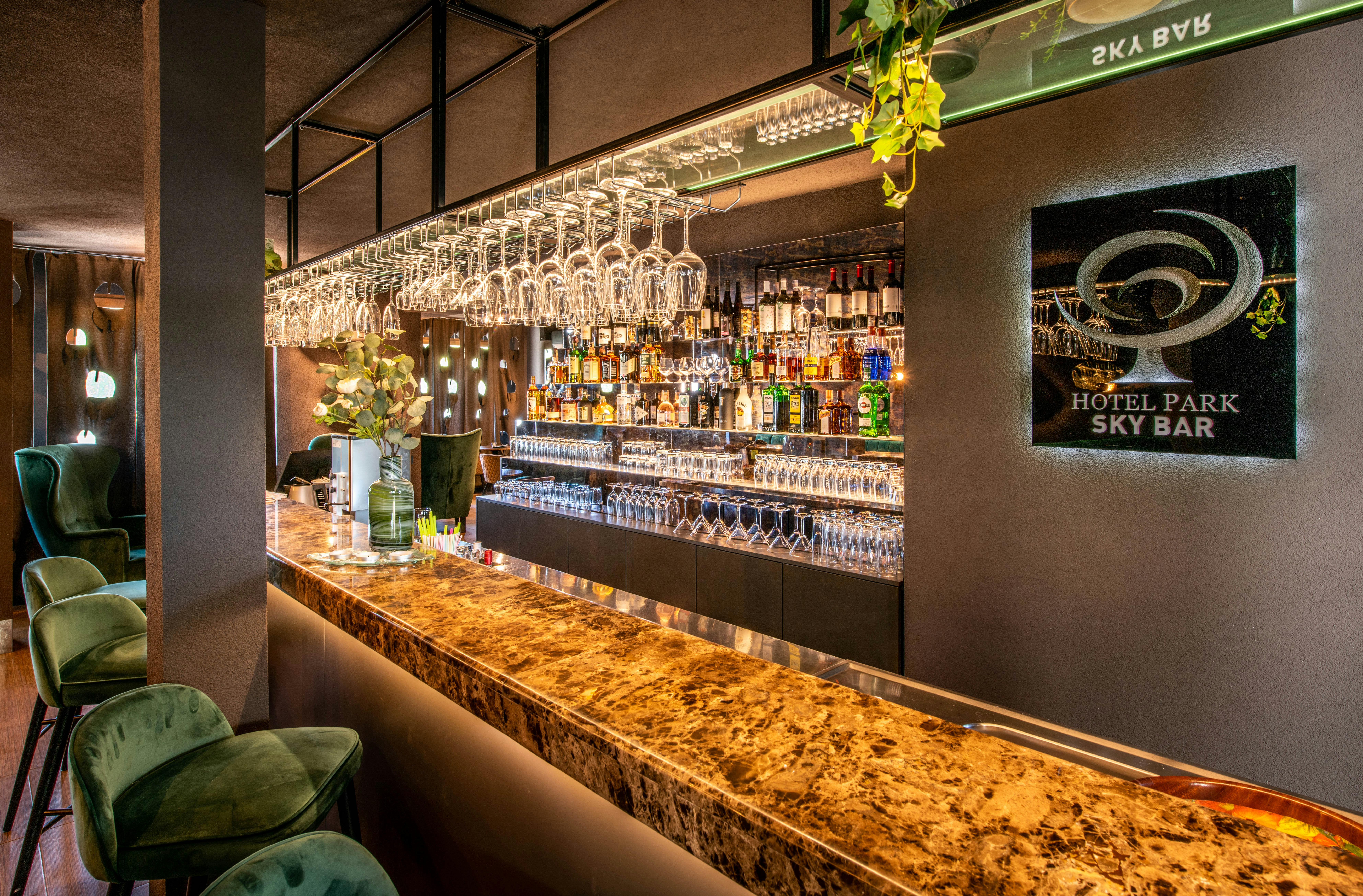 Sophisticated private members club interior with deep green velvet seating, brass bar fixtures, and intimate lighting