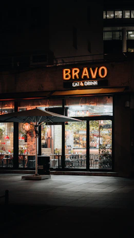 A welcoming storefront of brilhovila with warm lighting at dusk.