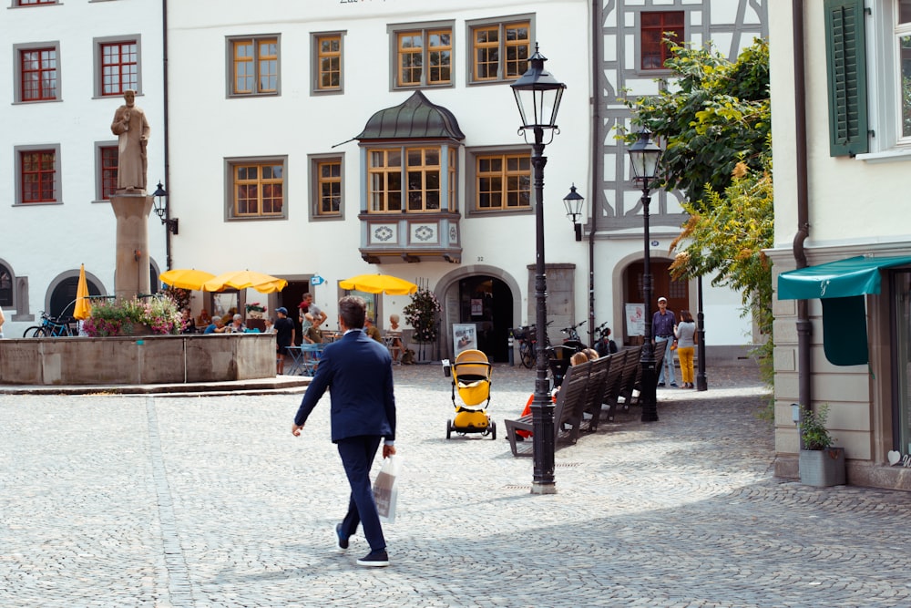 a man walking down a street holding an umbrella