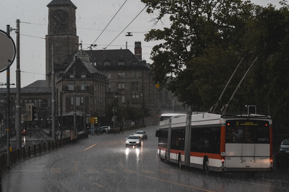 a bus driving down a street next to a tall building