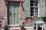 Close-up of a rustic wooden door with olive green shutters, typical of the hotel's charming style.