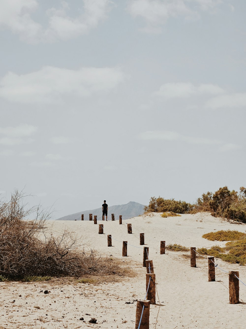 a man standing on top of a sandy beach