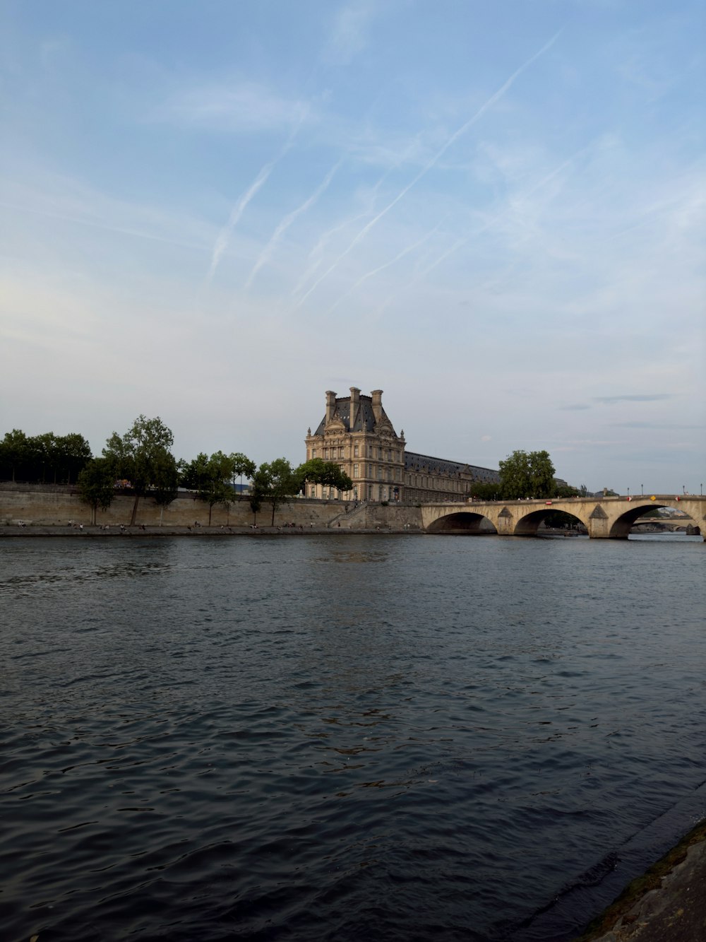 a bridge over a body of water with a castle in the background