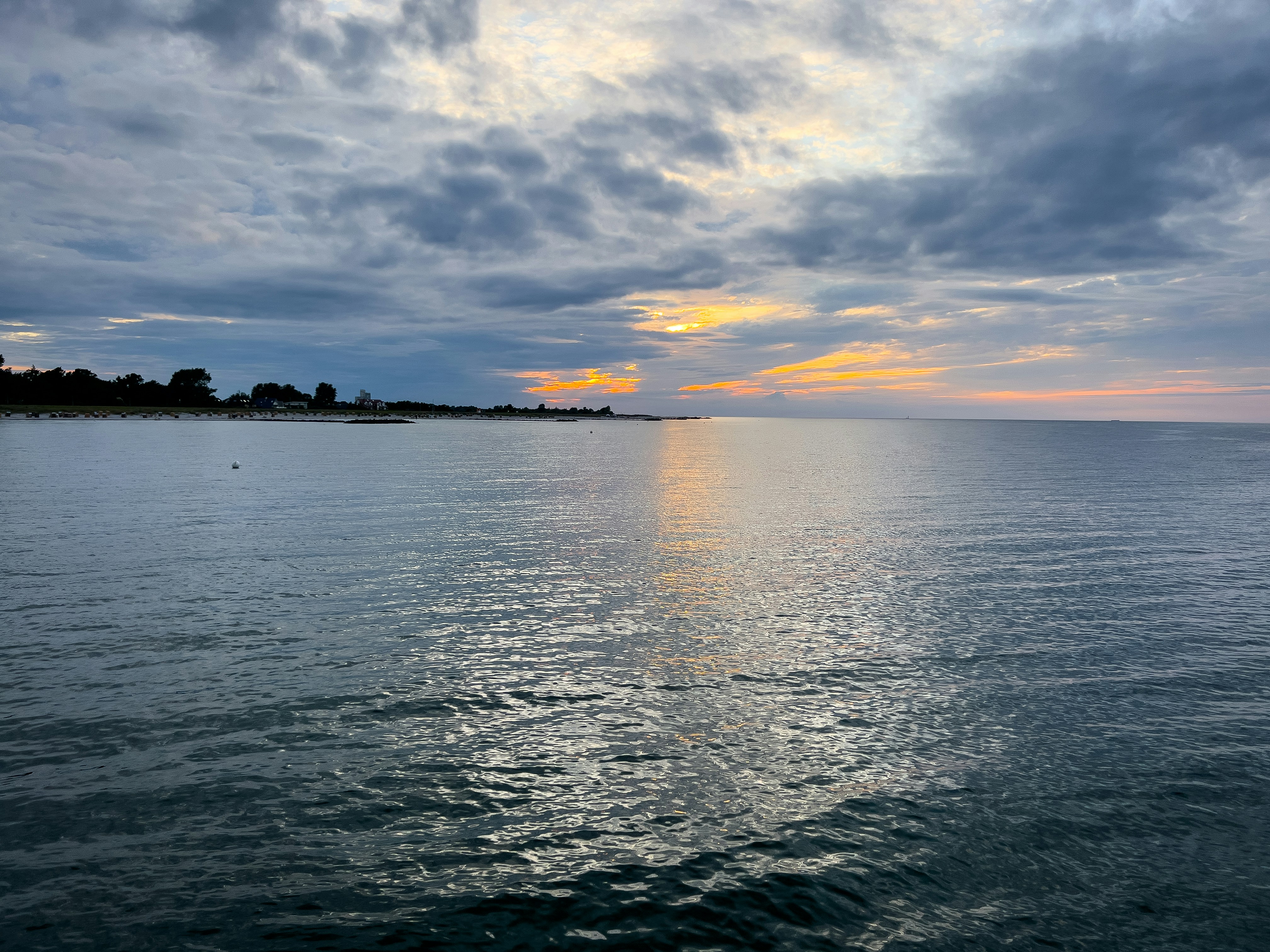 Uno specchio d'acqua con un cielo pieno di nuvole