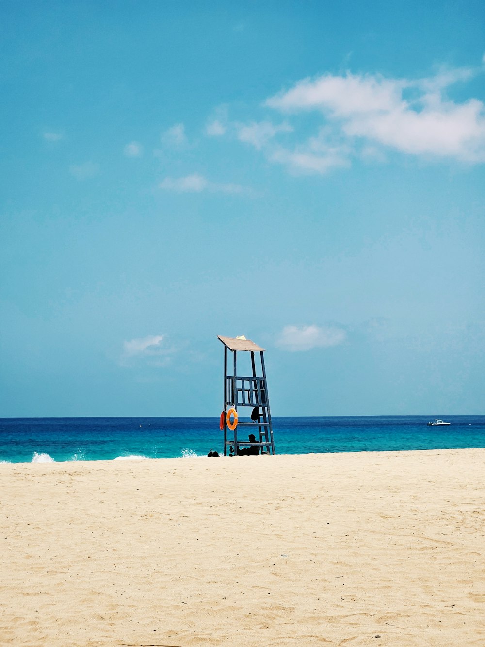 a lifeguard tower on a beach with a blue sky