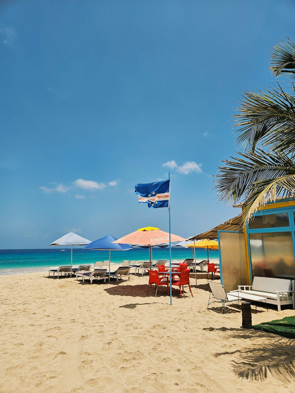 a sandy beach with chairs and umbrellas on it
