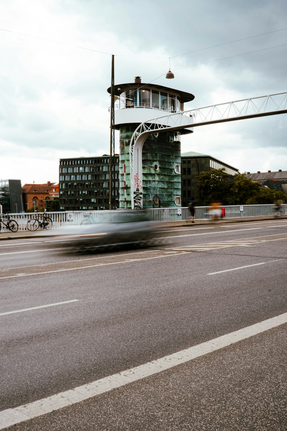 a car driving down a street past a tall building