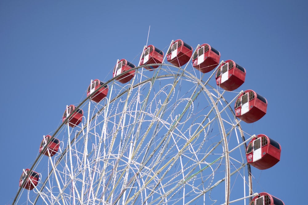 a ferris wheel with red seats against a blue sky
