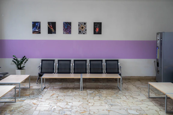 a row of benches sitting next to a wall