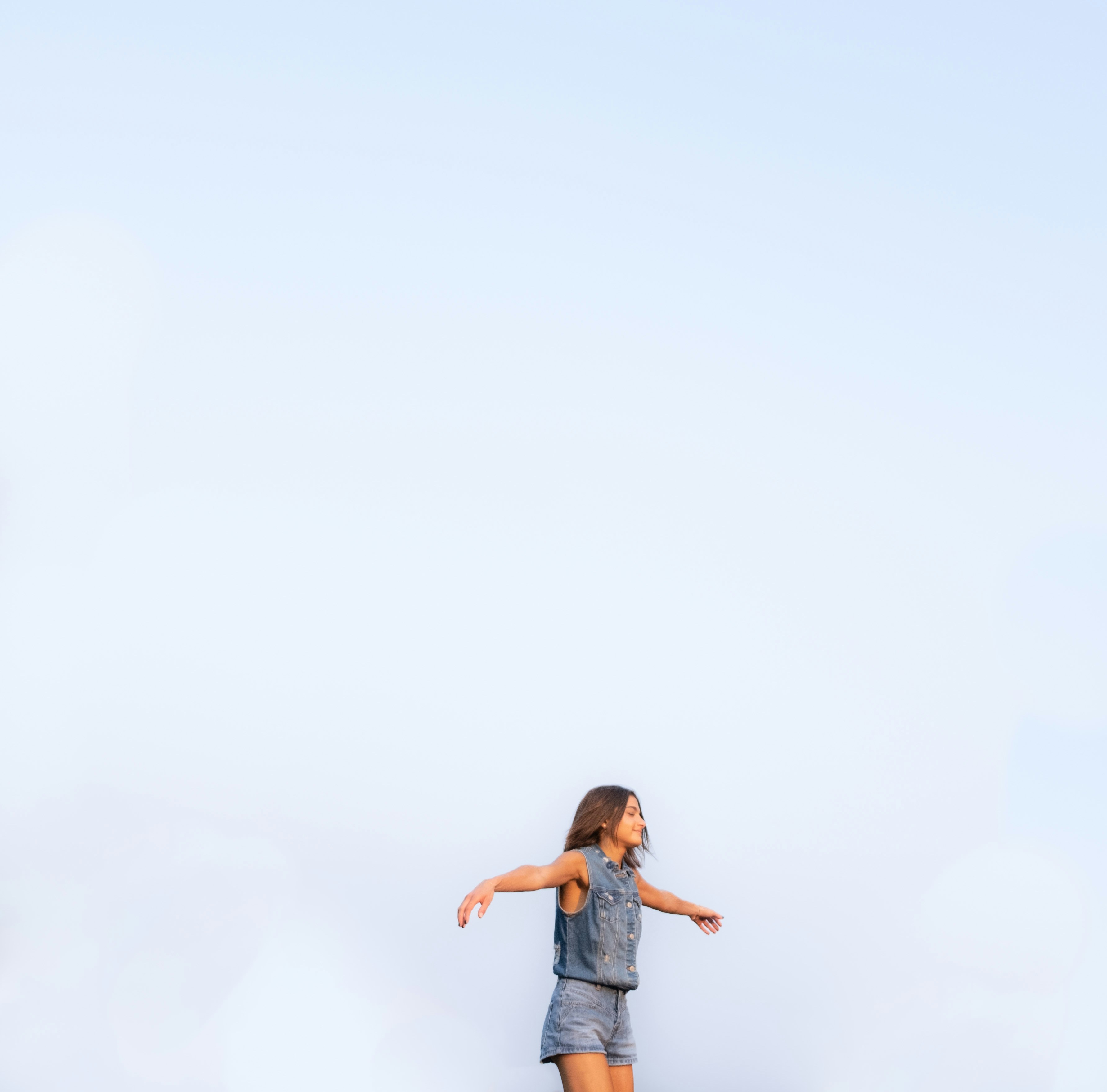 a girl is flying a kite in the sky