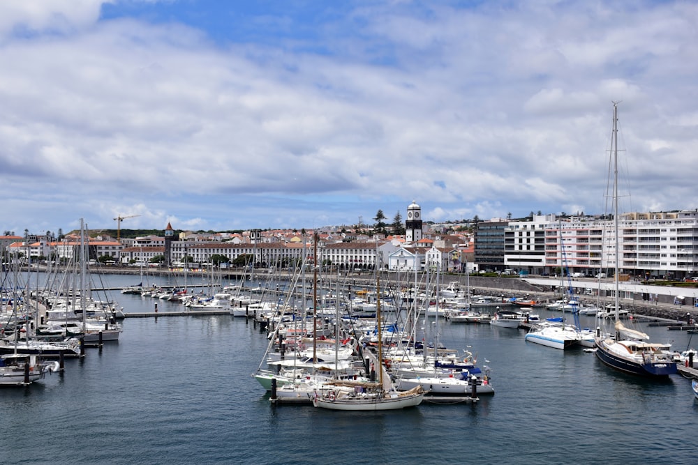 a harbor filled with lots of boats under a cloudy blue sky