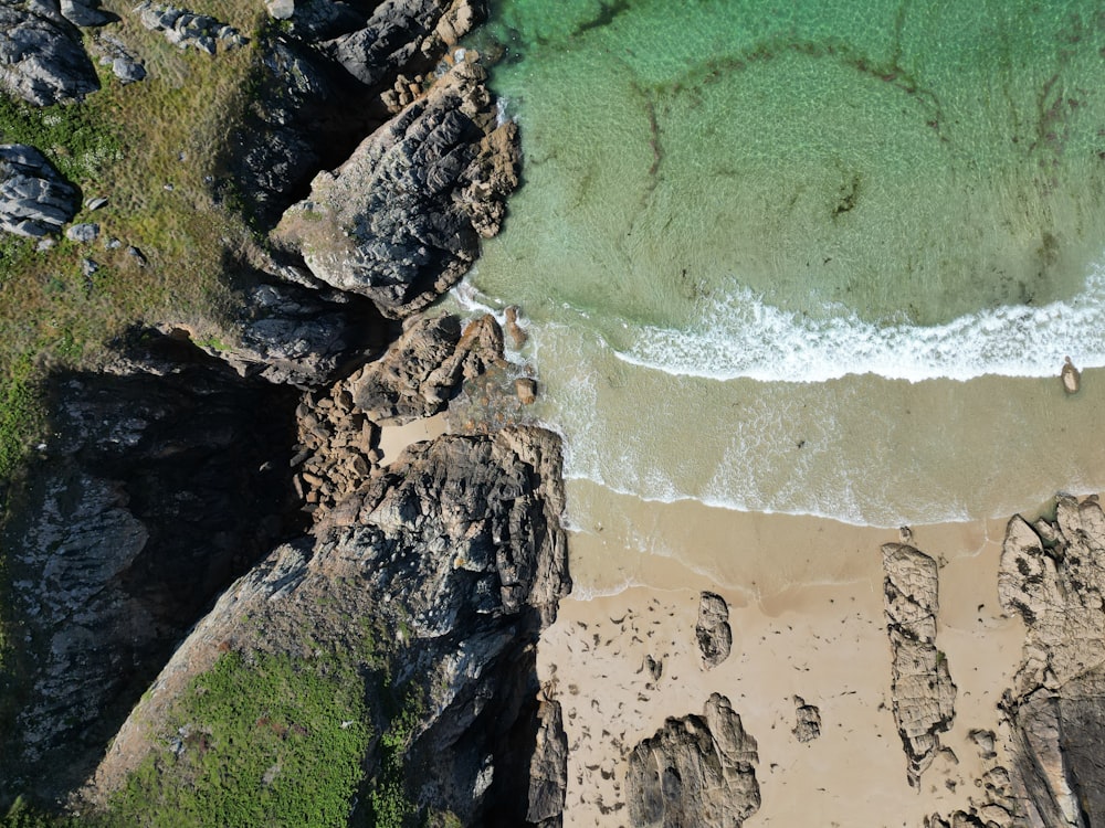 an aerial view of a sandy beach with green water