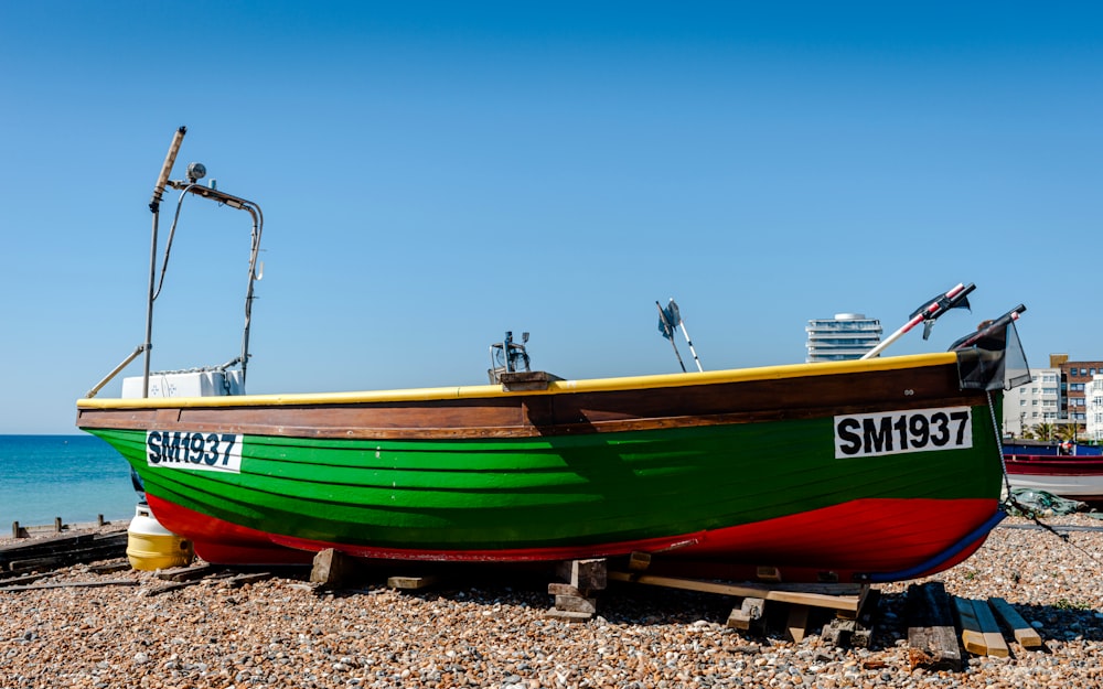 a boat sitting on top of a beach next to the ocean