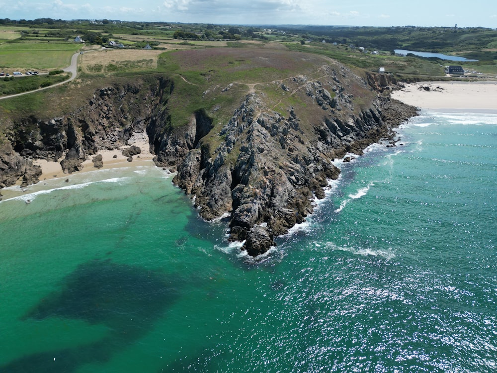 an aerial view of a beach with a rock outcropping