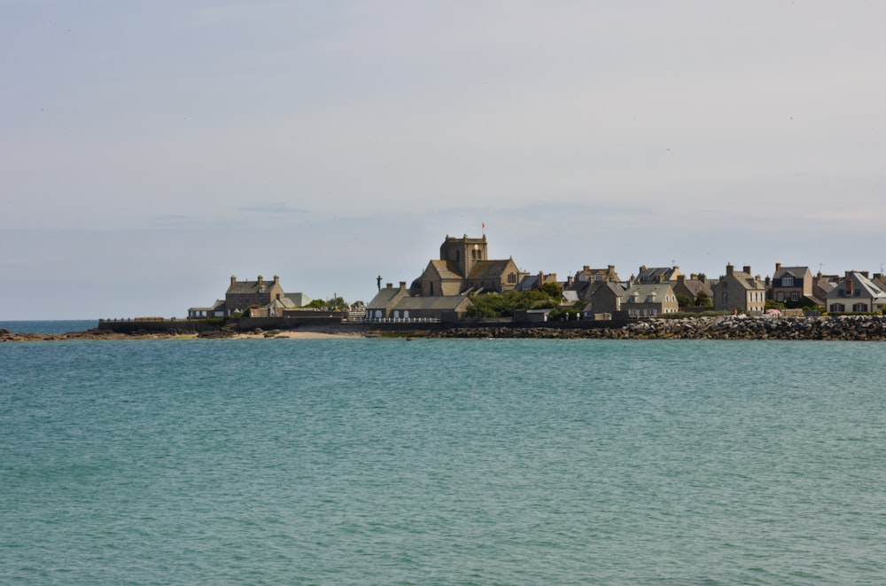 a large body of water with houses in the background