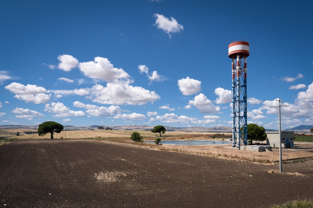 a large field with a water tower in the middle of it