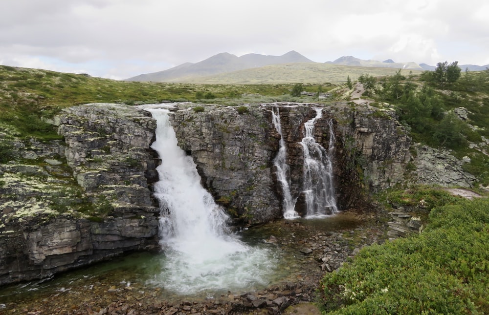 a large waterfall with water cascading down it's sides