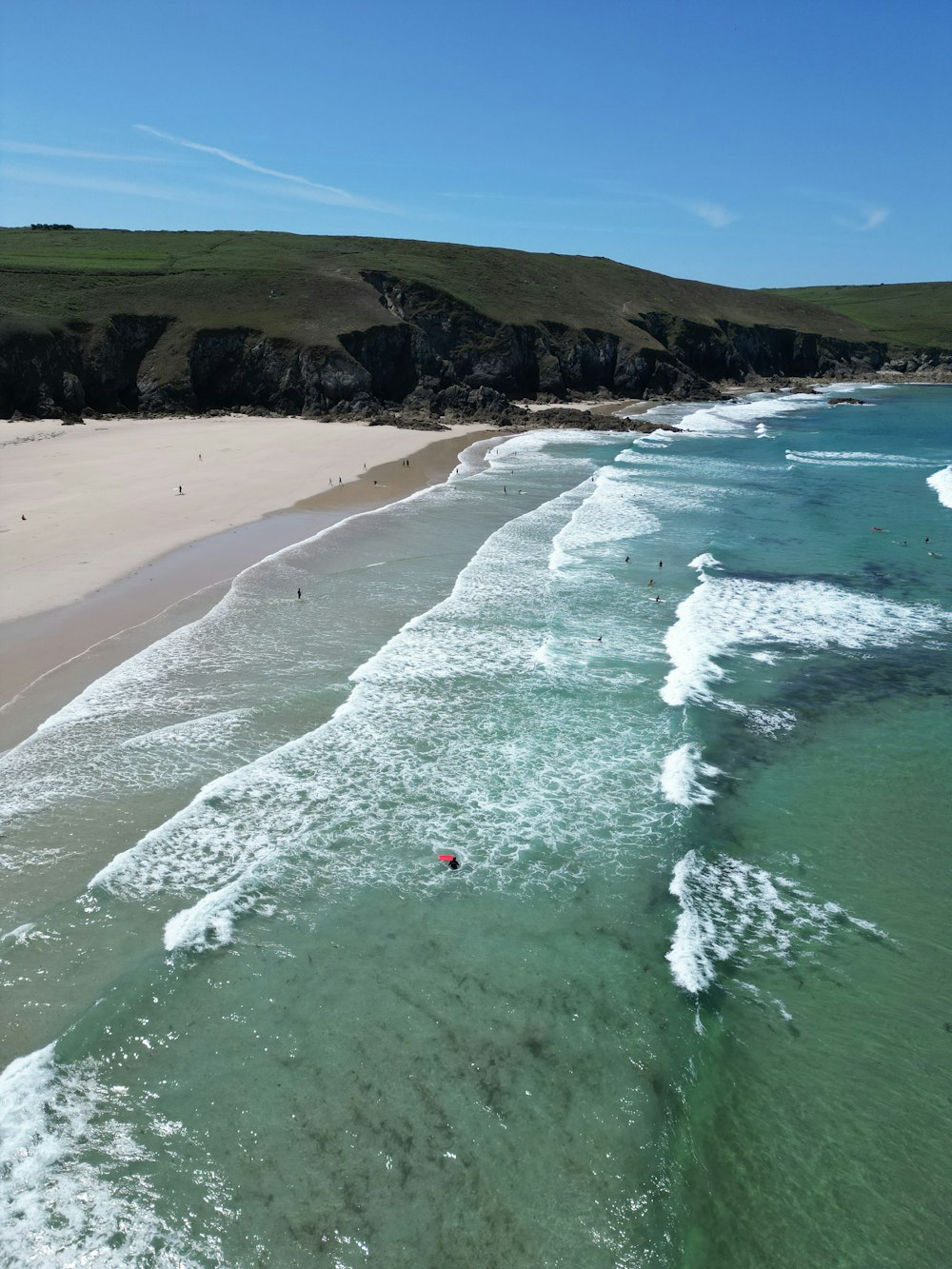 Una vista aérea de una playa con gente en el agua