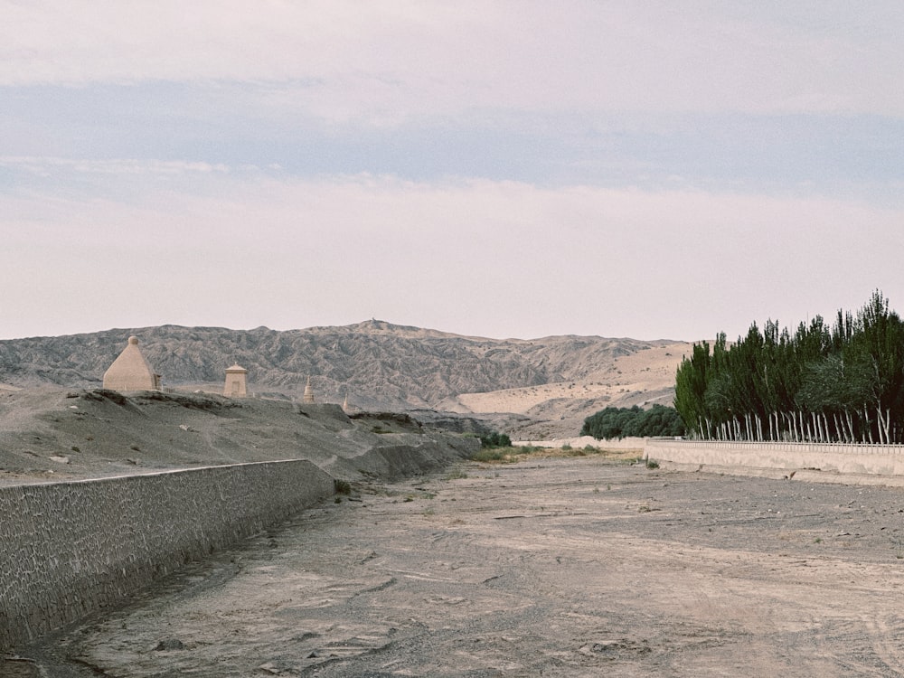 a dirt road with a mountain in the background