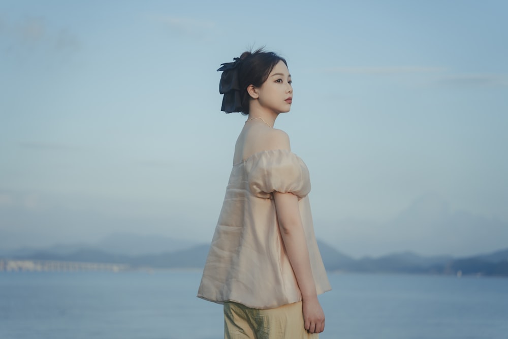 a woman standing on a beach next to the ocean