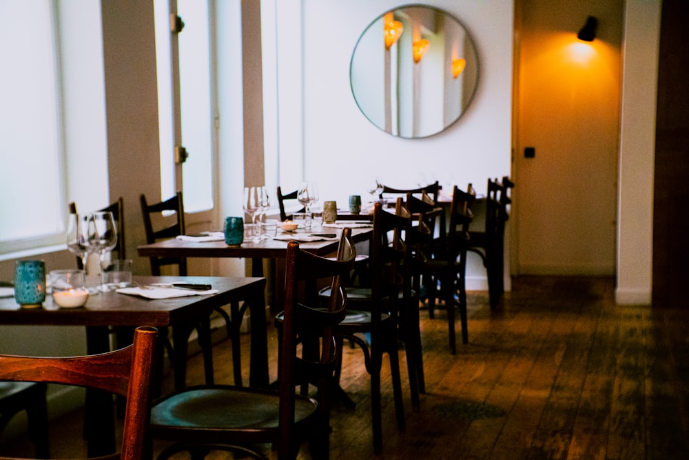 a dining room with tables and chairs and a mirror on the wall