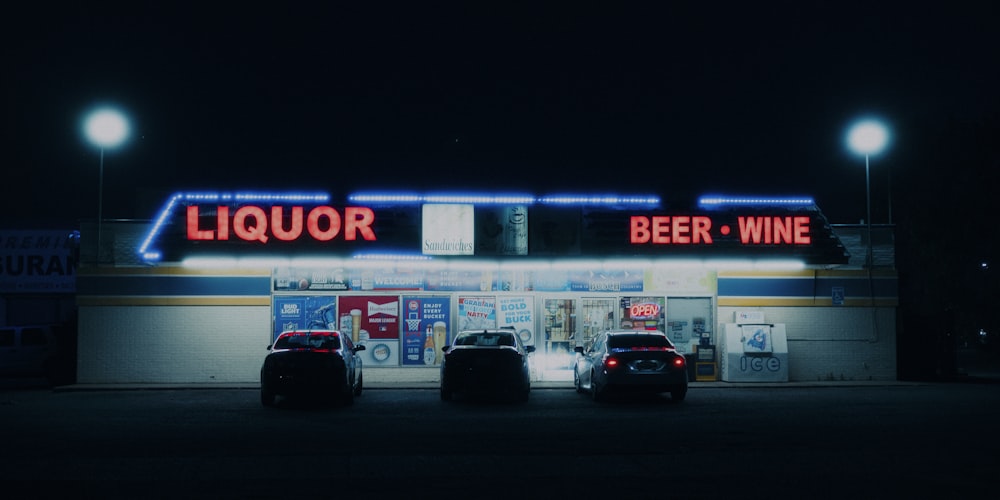 two cars parked in front of a liquor store