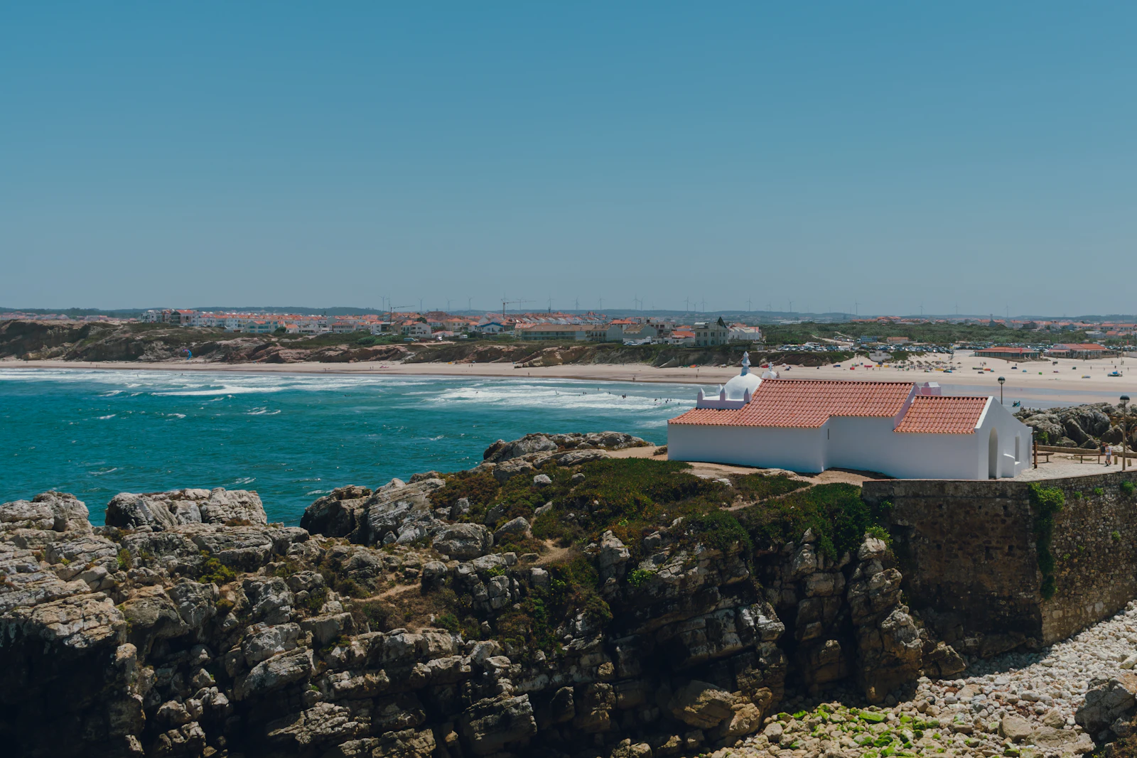 The chapel on the rocks at Baleal, with the beach and town of Peniche, Portugal behind