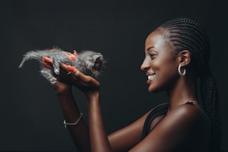 A smiling team member holding a rescued kitten, showcasing the heart of our nonprofit work.