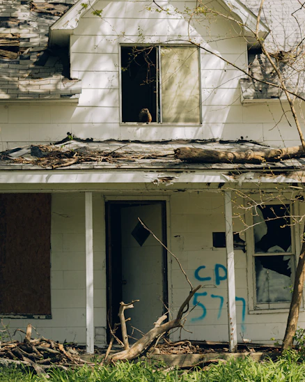 a run down house with graffiti on the side of it