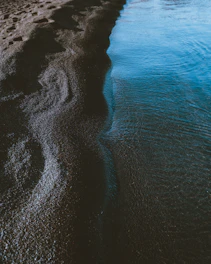 A serene close-up of natural textures blending water and sand, evoking calm and purity.