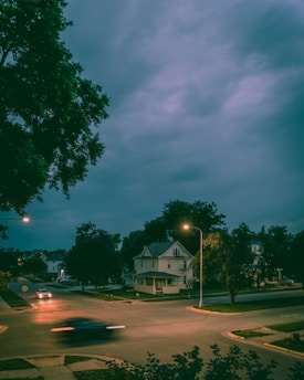 A serene twilight scene of a learner driver confidently navigating a quiet suburban street under soft streetlights.