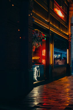 A cozy storefront of Reno Budz at 693 Broadway, Brooklyn, with a welcoming evening glow.