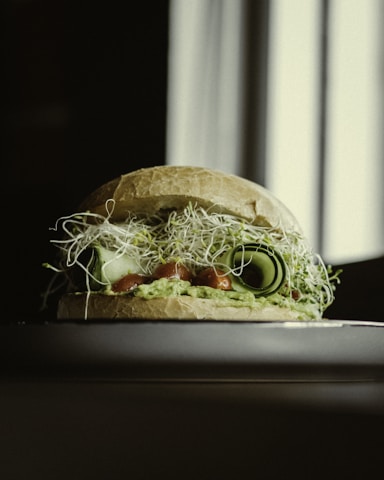 Close-up of a chef layering fresh ingredients on toasted artisan bread during a hands-on sandwich workshop.