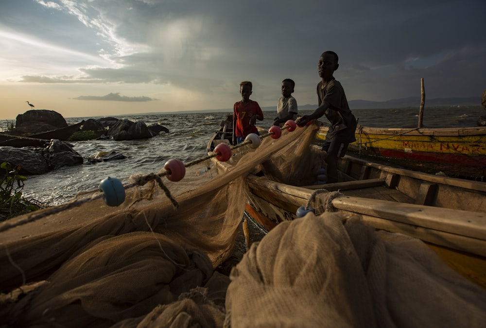 a group of people standing on top of a boat near the ocean