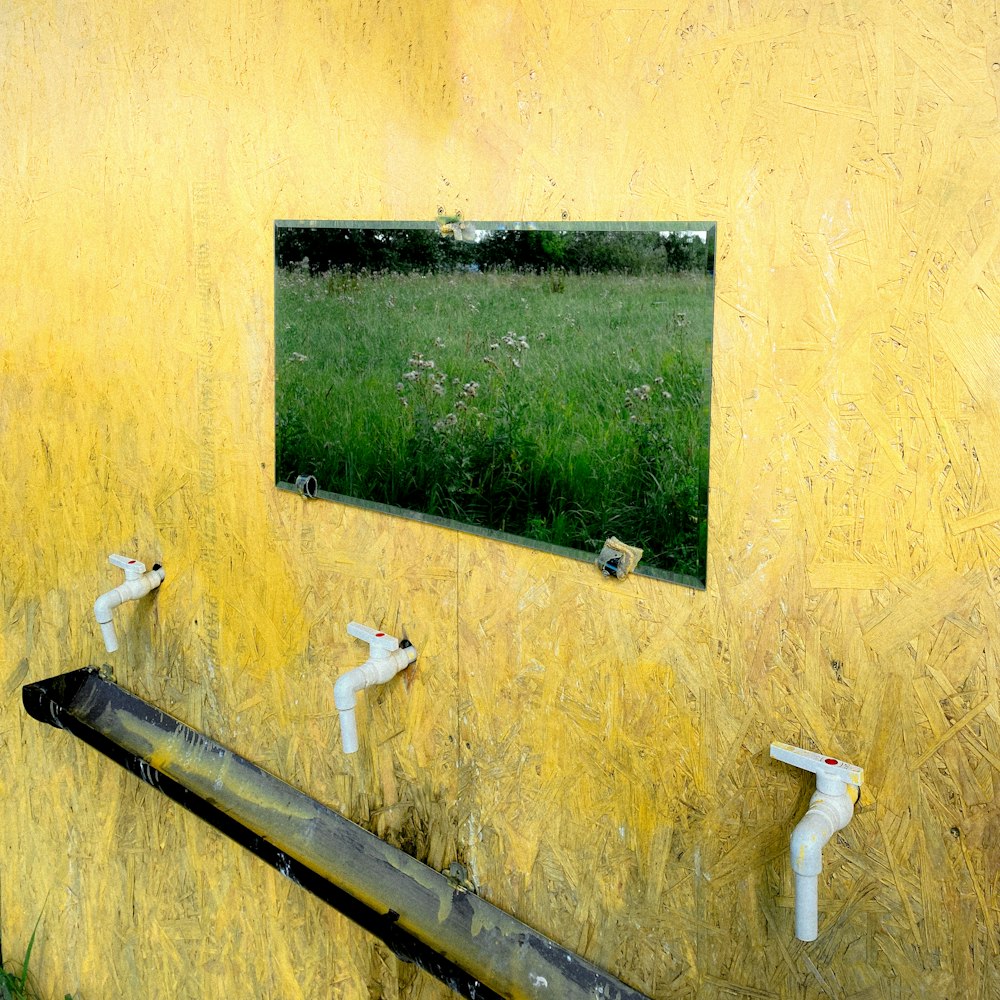 a yellow wall with a mirror on it