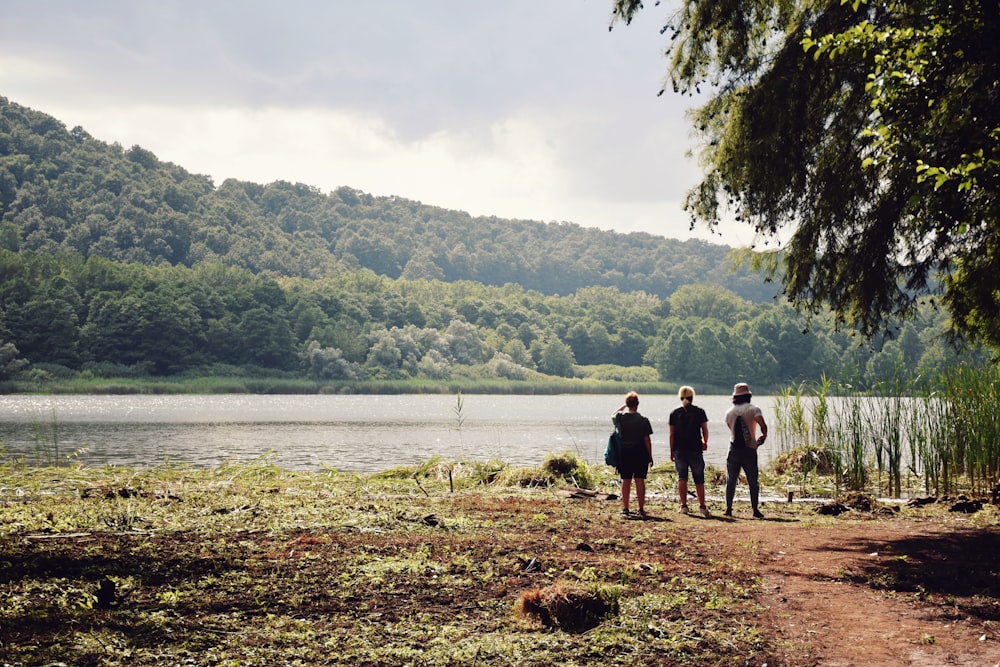 a group of people standing next to a body of water