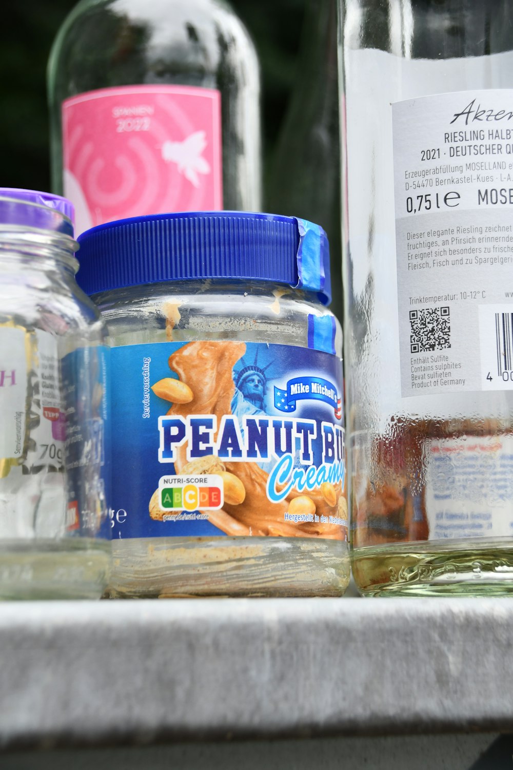 jars of peanut butter and jelly are sitting on a counter