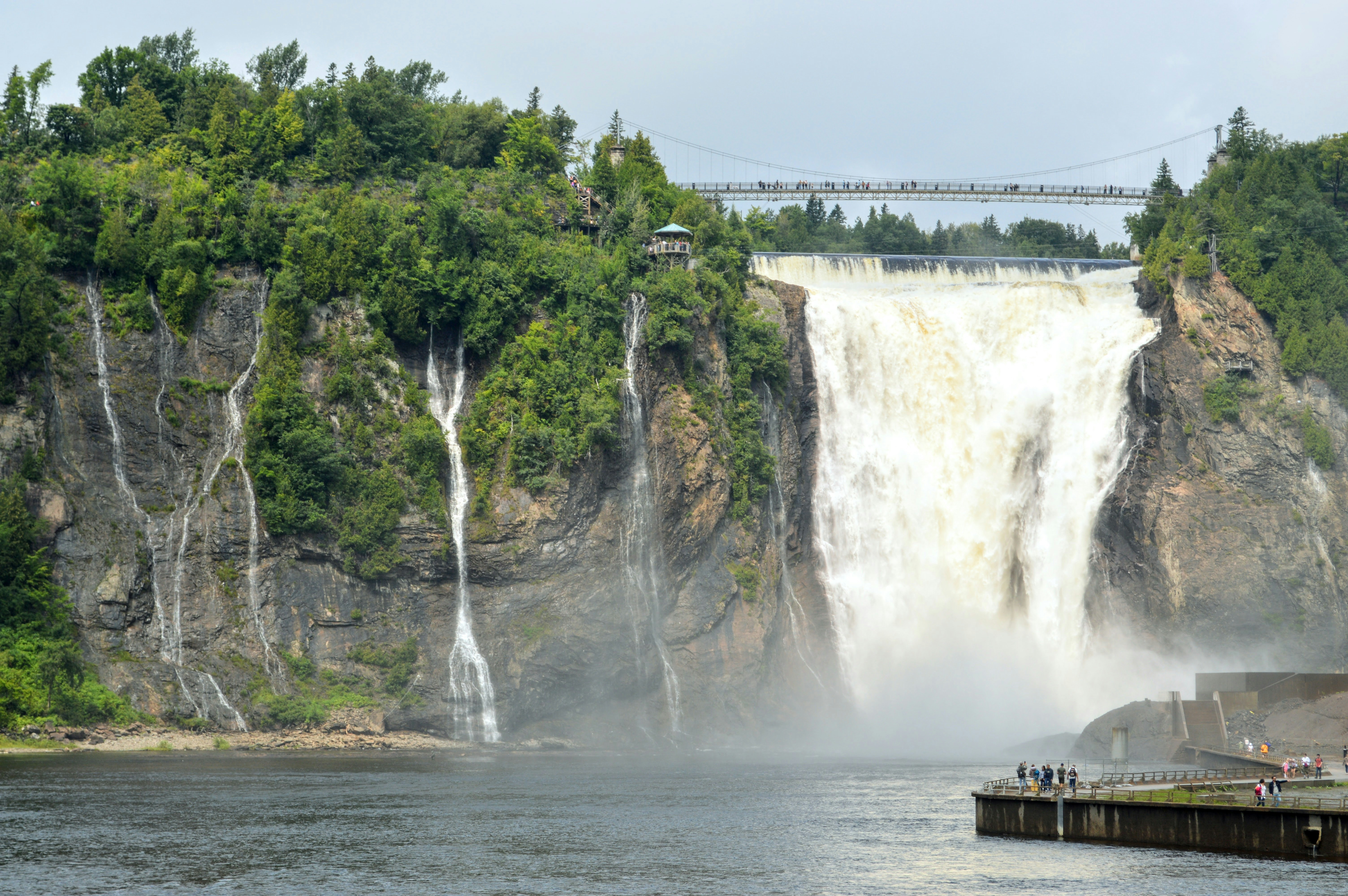 a large waterfall with a bridge above it