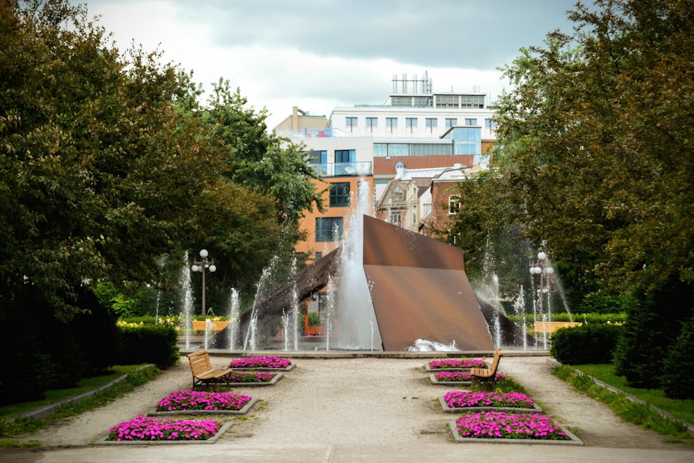 a park with a fountain and benches in the middle of it