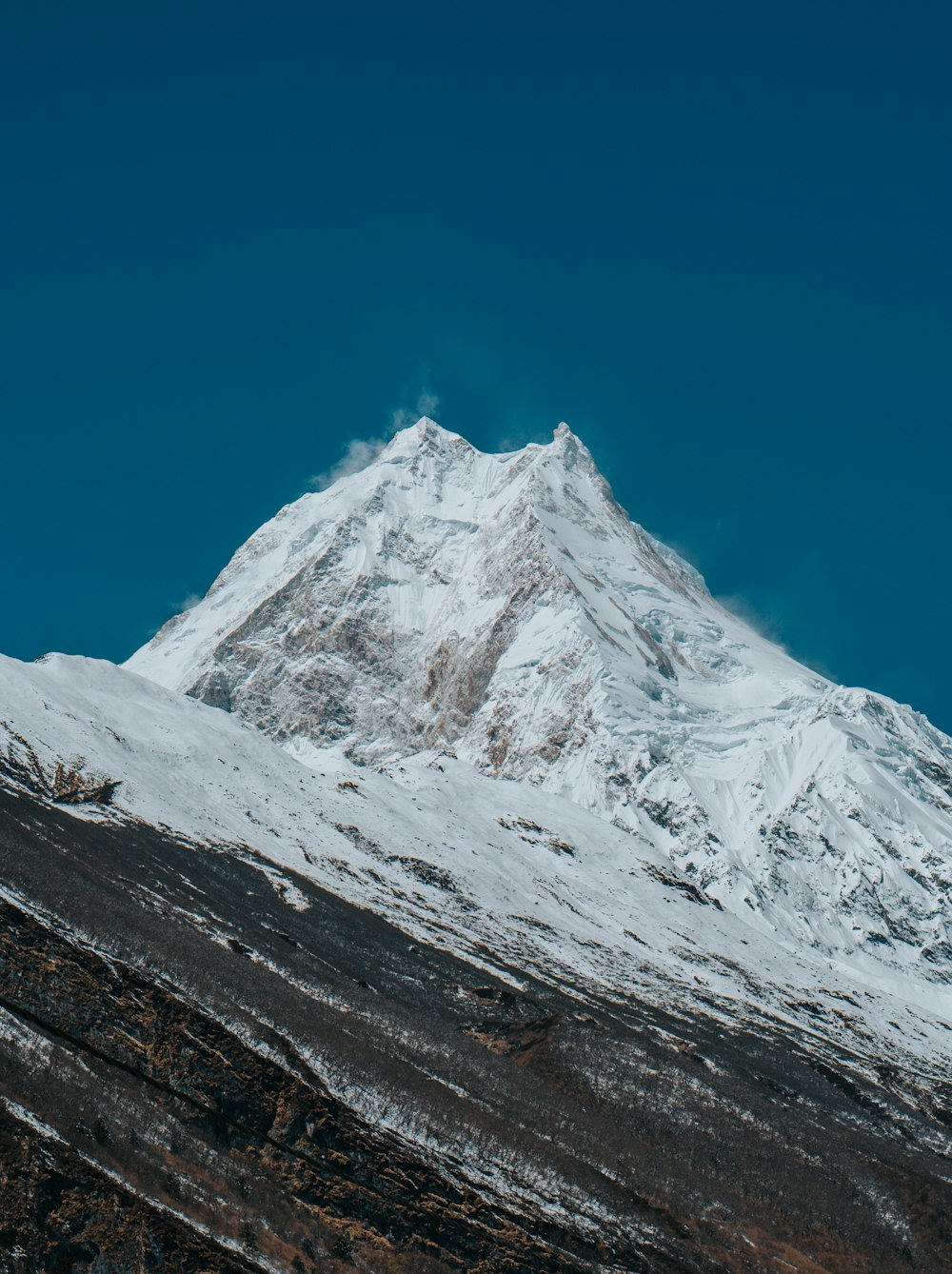 a snow covered mountain with a blue sky in the background