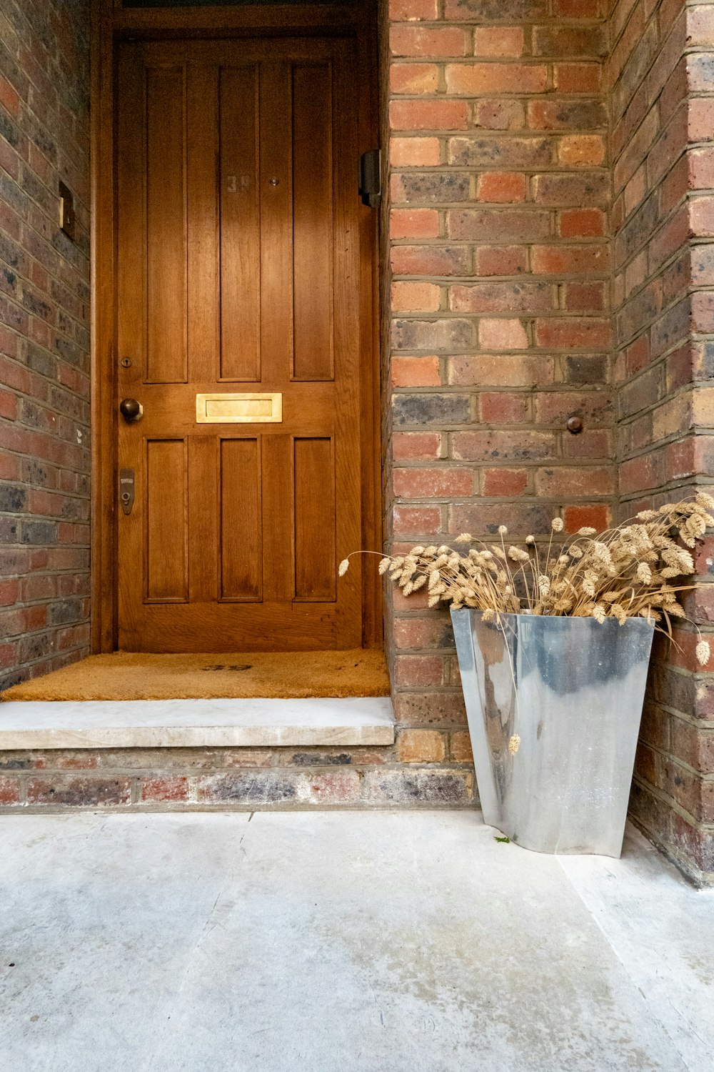 a metal planter sitting in front of a wooden door