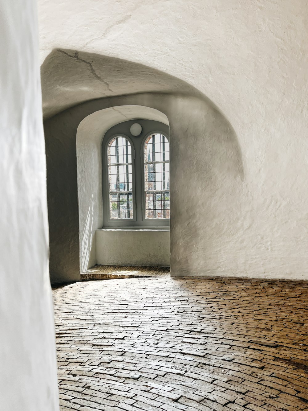 a room with a brick floor and a window