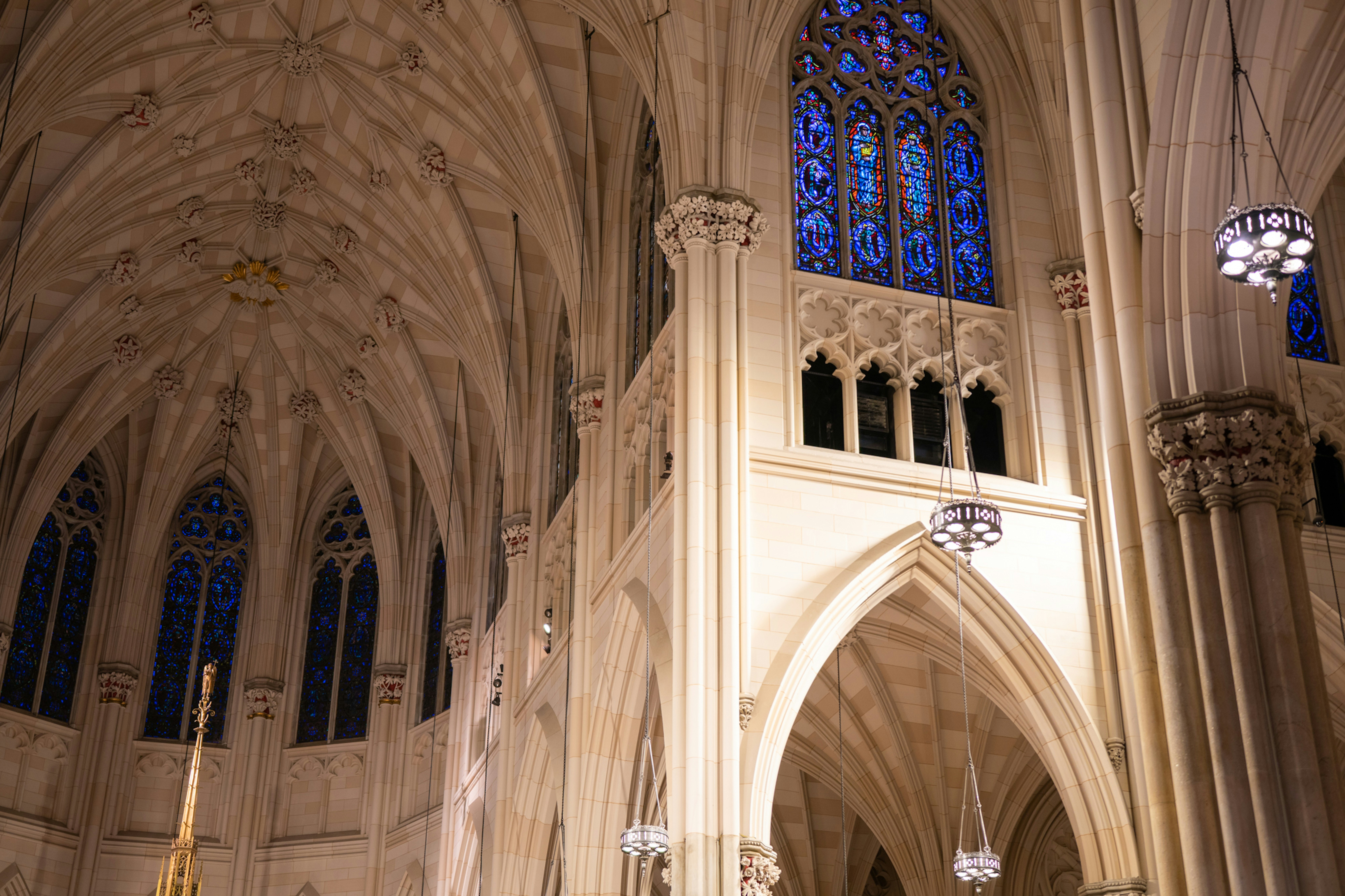 the inside of a cathedral with chandeliers and stained glass windows