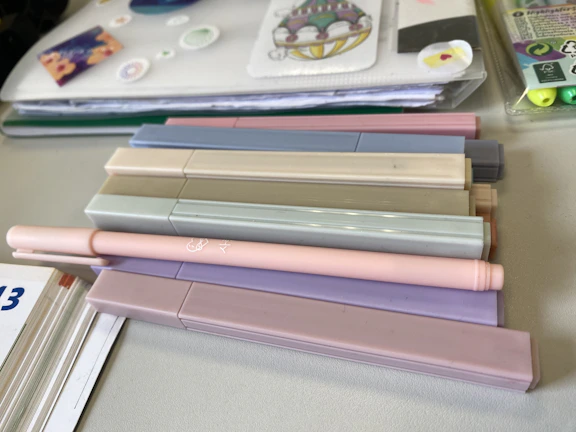 Close-up of pastel mildliner pens arranged on a cream background with sparkly accents.