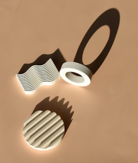 A minimalist 3D design piece displayed in a bright studio setting, emphasizing its form and shadow play.